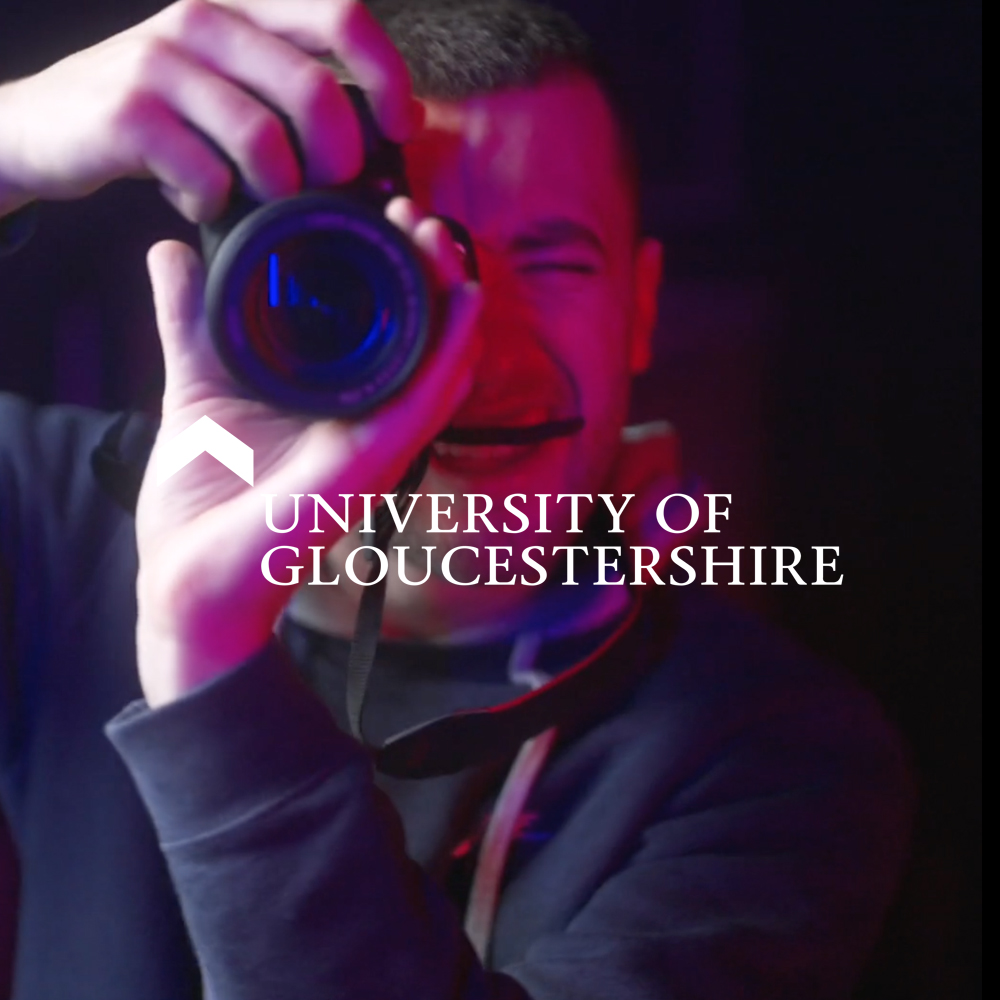 University of Gloucestershire creative department promotional video. A student holds a photography camera up to the lens.