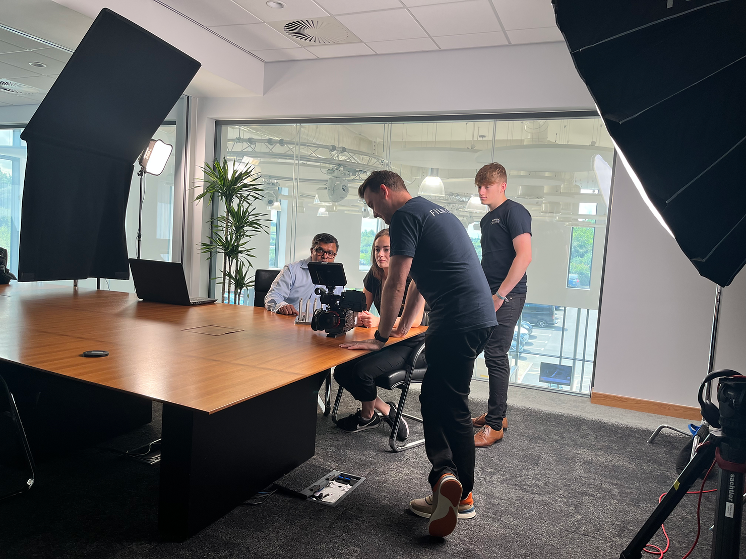 A Behind-The-Scenes photograph of video crew recording in an office meeting room